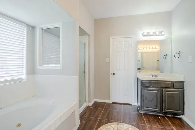 a bathroom with a tub sink and a mirror