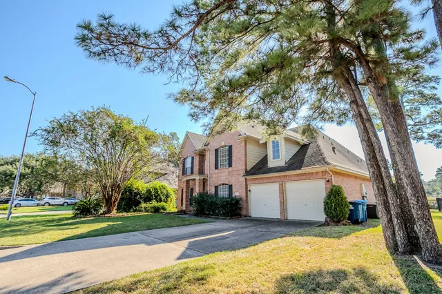 a front view of a house with a yard and trees