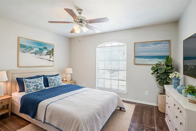 a bedroom with a large bed and a potted plant