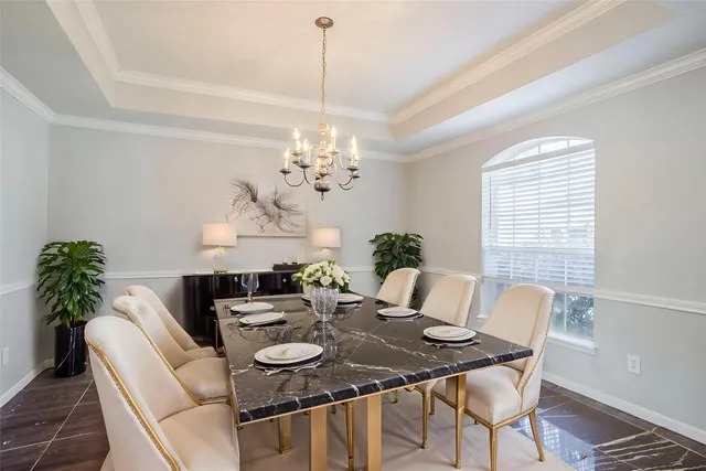 a view of a dining room with furniture a chandelier and wooden floor