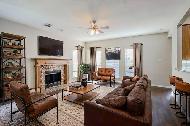 a living room with furniture a flat screen tv and a fireplace