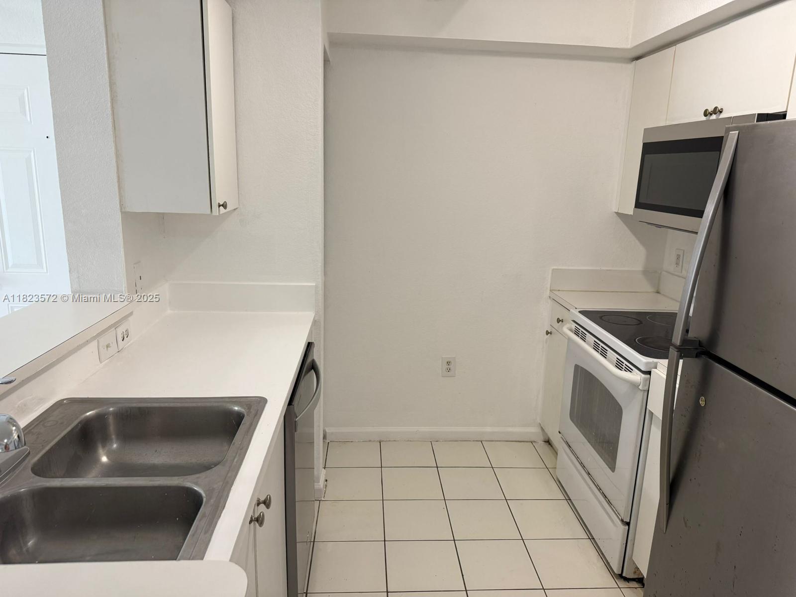 15422 Southwest 284th Street, Unit 7207 Homestead, FL 33033 - Photo 5 of 36 a kitchen with white cabinets and stainless steel appliances