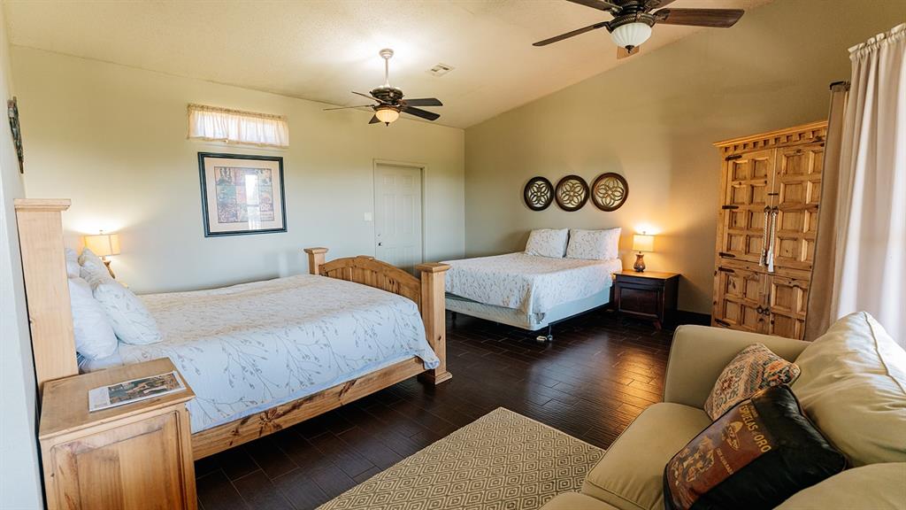 175 Tobacco Road Whitney, TX 76692 - Photo 23 of 35 Bedroom featuring vaulted ceiling, dark wood finished floors, and a ceiling fan