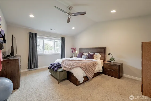 a spacious bedroom with a bed and a flat screen tv