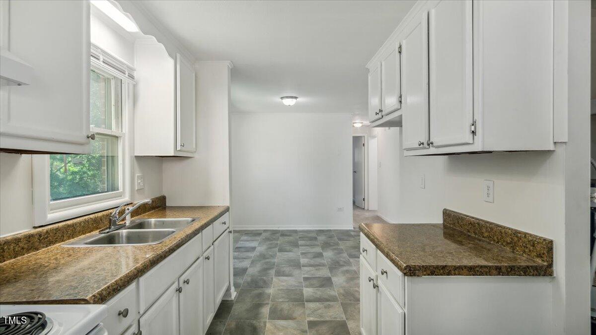2530 Spring Valley Road Henderson, NC 27537 - Photo 4 of 45 a kitchen with granite countertop a sink stove and cabinets