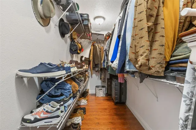 a view of walk in closet with clothes and shoes