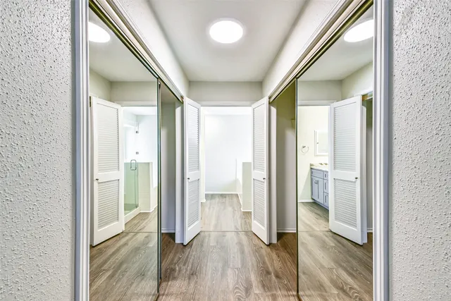 a view of a hallway with wooden floor and staircase
