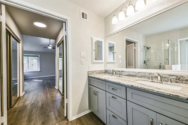 a en suite bathroom with a granite countertop sink toilet and a mirror