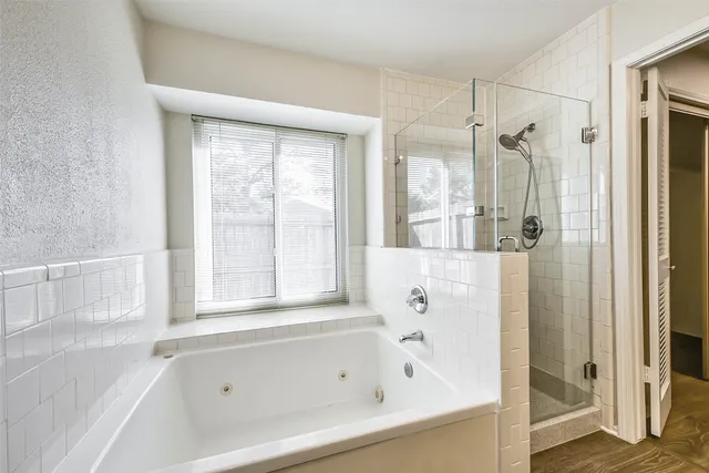a white bath tub sitting next to a shower