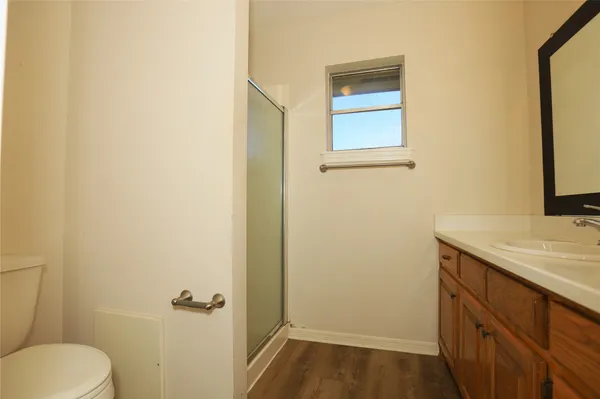 a bathroom with a granite countertop sink and a toilet