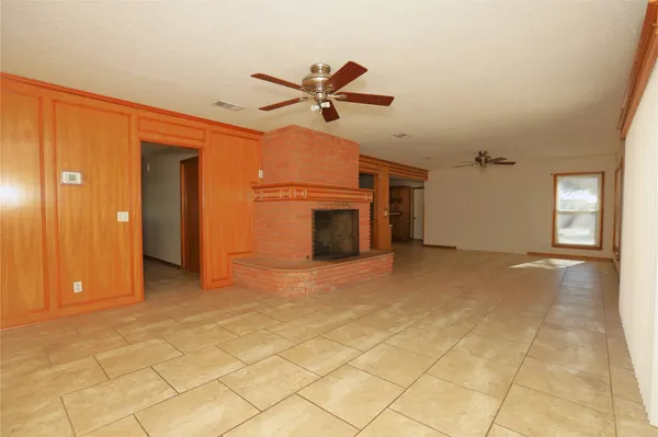 a view of a livingroom with a chandelier fan and windows