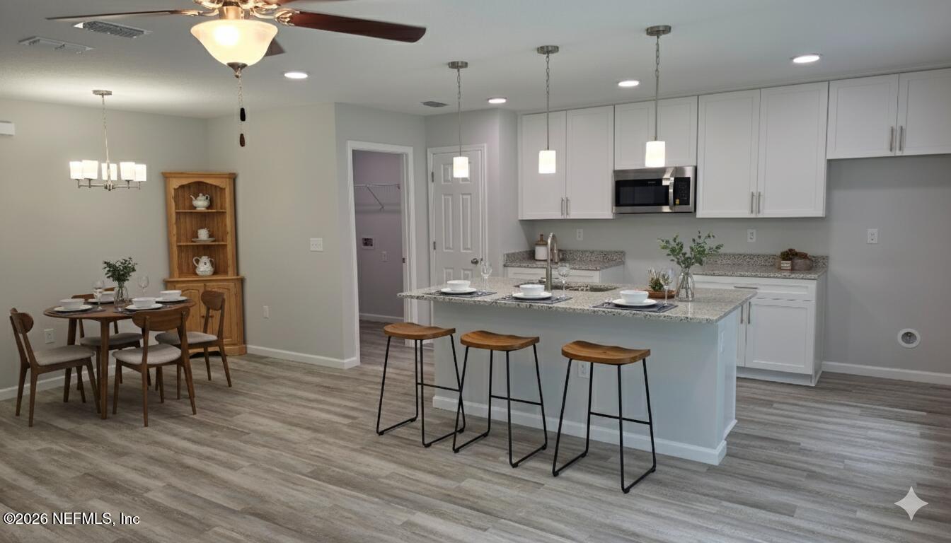 1082 Cahoon Road South Jacksonville, FL 32221 - Photo 5 of 9 a kitchen with stainless steel appliances kitchen island granite countertop a dining table chairs and sink
