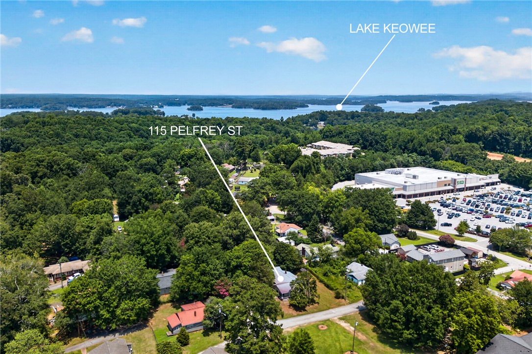 115 Pelfrey Street Seneca, SC 29672 - Photo 2 of 46 An aerial perspective reveals the property's location amidst lush trees, with Lake Keowee sparkling in the distance.