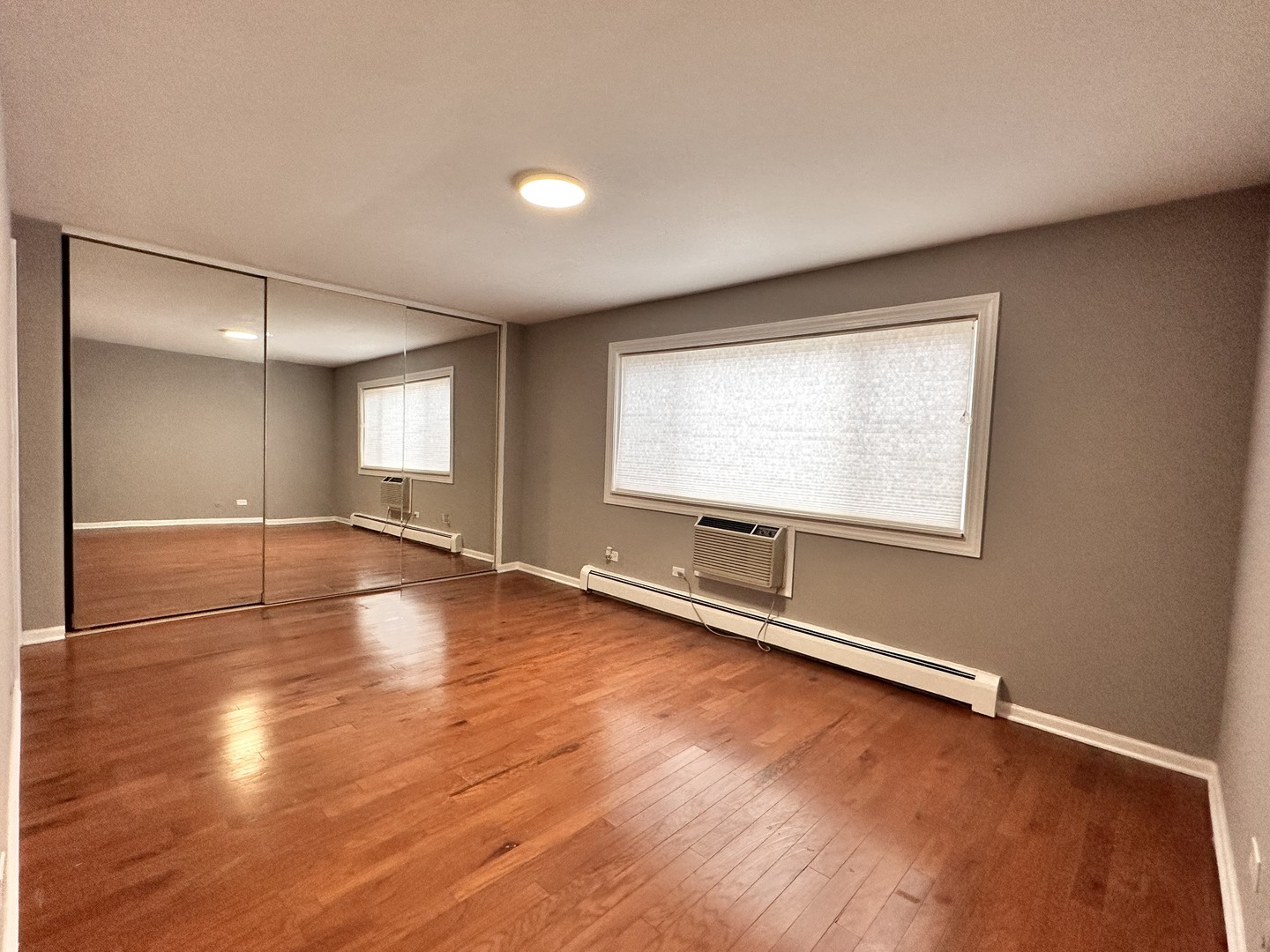 10357 Dearlove Road, Unit 1K Glenview, IL 60025 - Photo 14 of 24 an empty room with wooden floor and windows