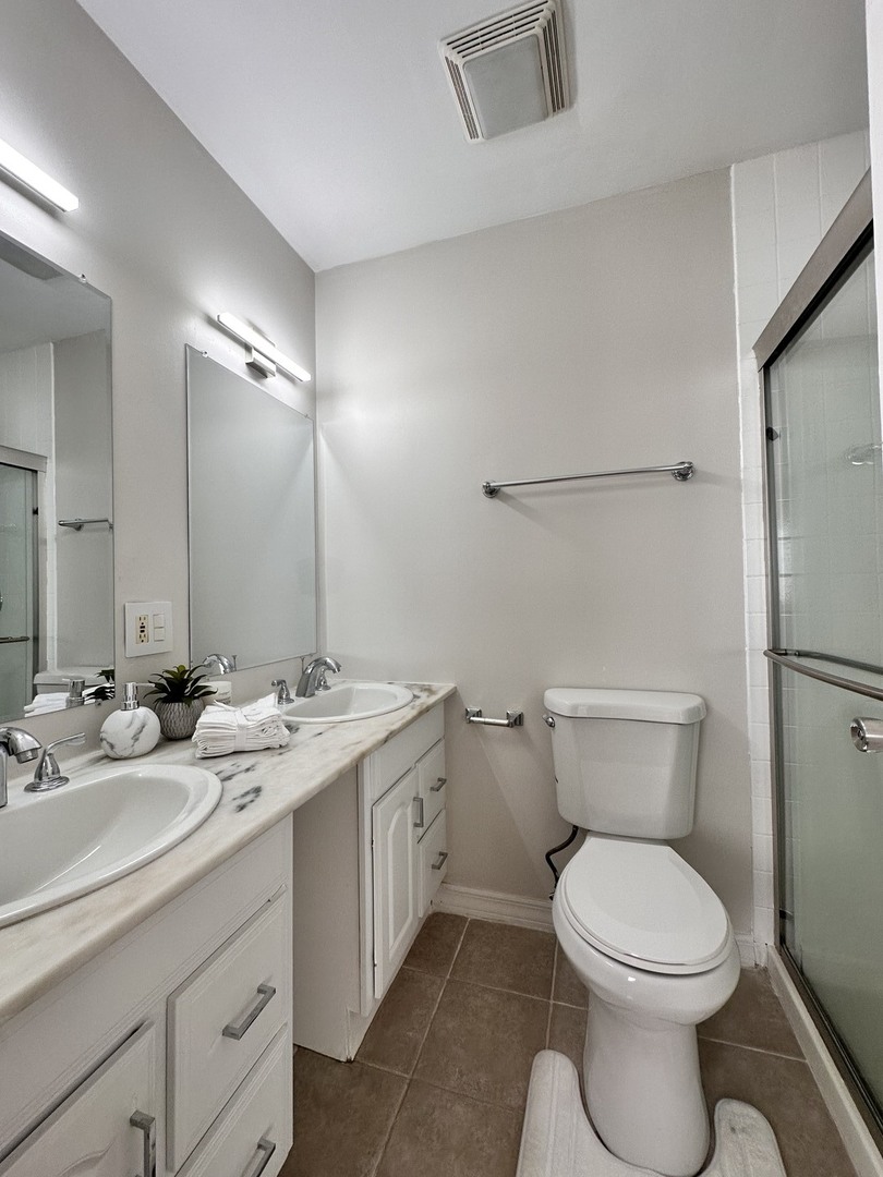 10357 Dearlove Road, Unit 1K Glenview, IL 60025 - Photo 16 of 24 a bathroom with a toilet sink and mirror