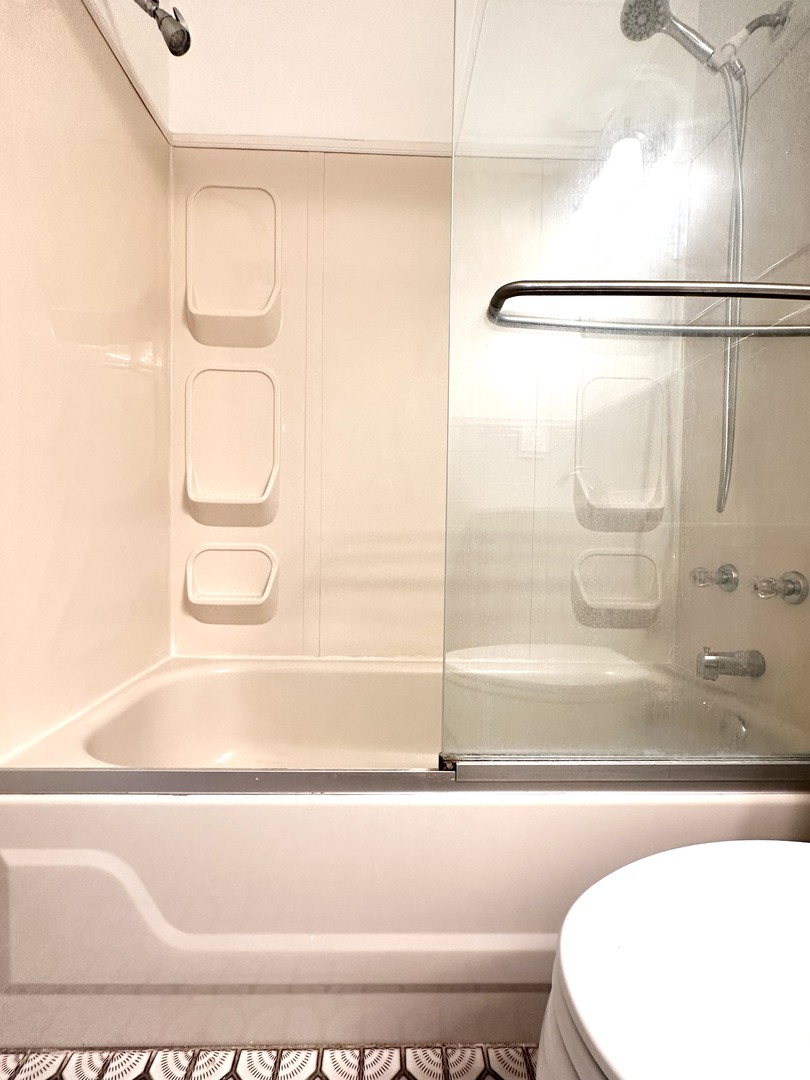 10357 Dearlove Road, Unit 1K Glenview, IL 60025 - Photo 19 of 24 a bathroom with a bathtub and a shower
