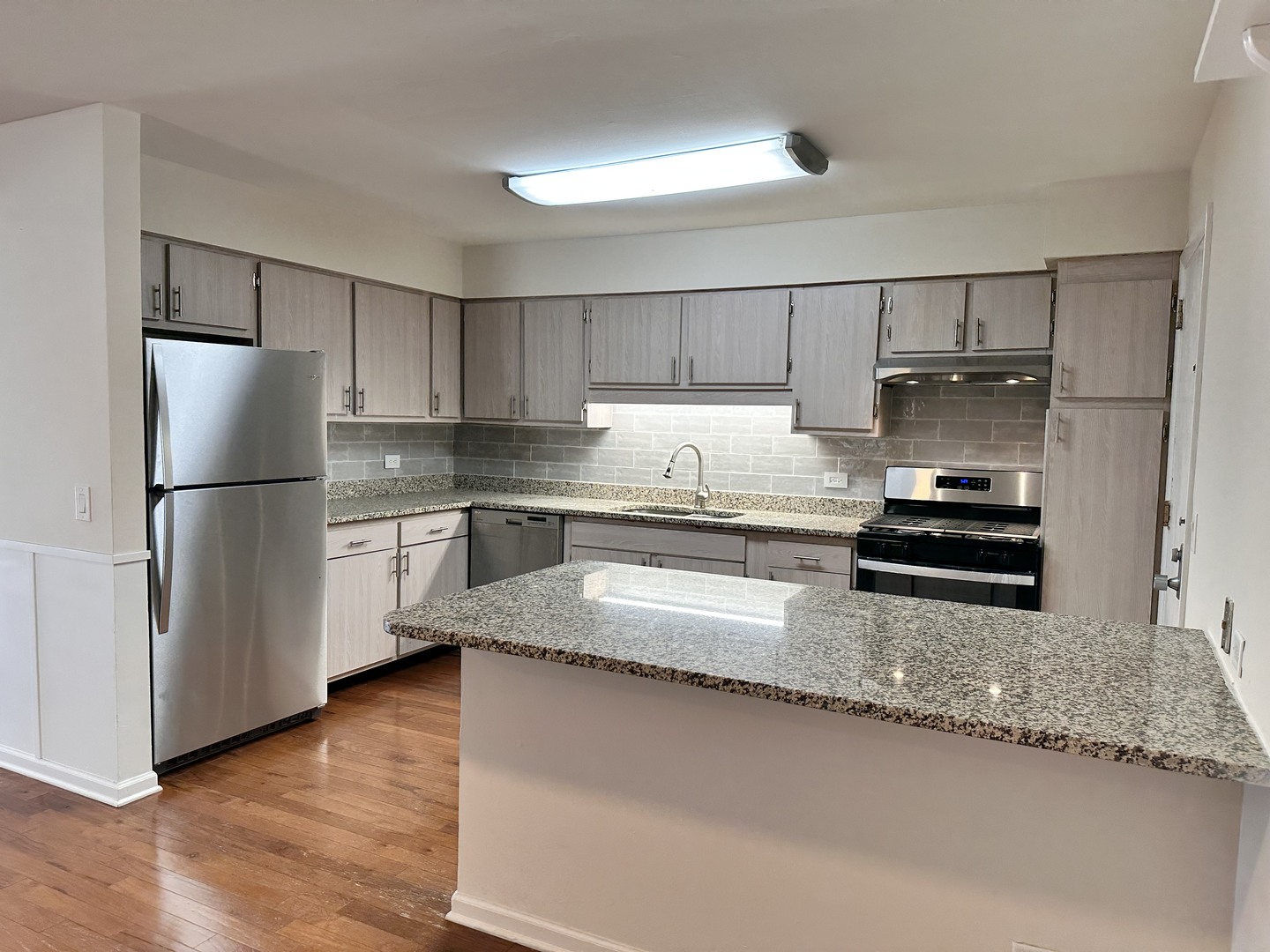 10357 Dearlove Road, Unit 1K Glenview, IL 60025 - Photo 9 of 24 a kitchen with granite countertop a refrigerator and a stove top oven