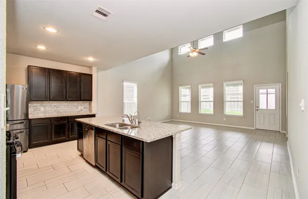a large kitchen with stainless steel appliances a sink dishwasher stove and cabinets