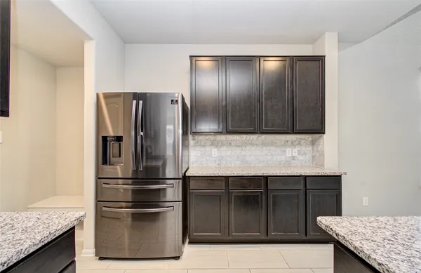 a kitchen with granite countertop stainless steel appliances and refrigerator