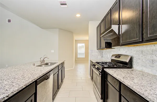 a kitchen with granite countertop stainless steel appliances and wooden cabinets
