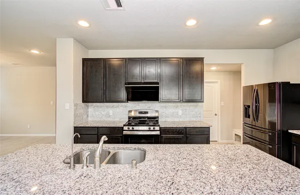 a kitchen with granite countertop a refrigerator and a sink