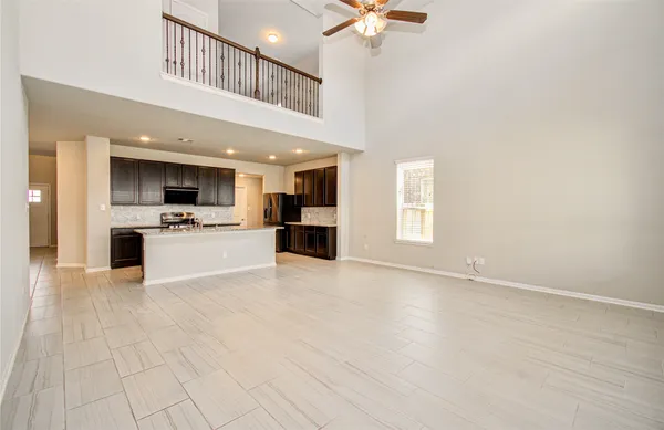 a view of a kitchen with kitchen island wooden floor and stainless steel appliances