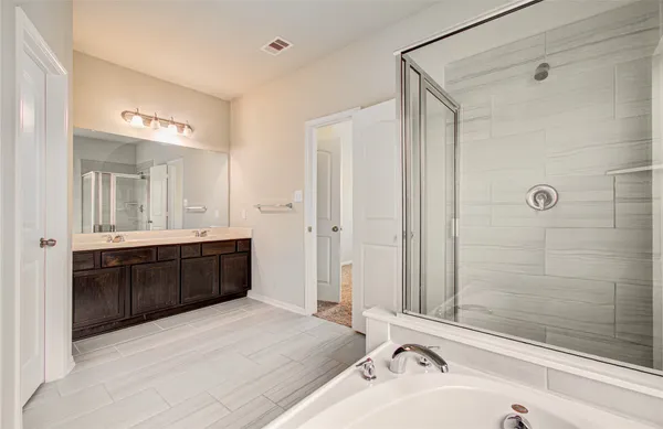 a bathroom with a tub a sink and a large mirror
