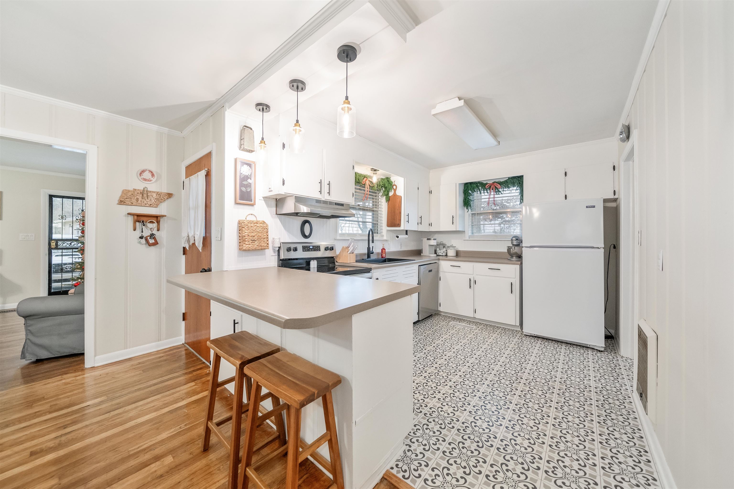 715 Burns Road Ramer, TN 38367 - Photo 14 of 20 Kitchen with white cabinetry, appliances with stainless steel finishes, pendant lighting, a breakfast bar area, and a peninsula
