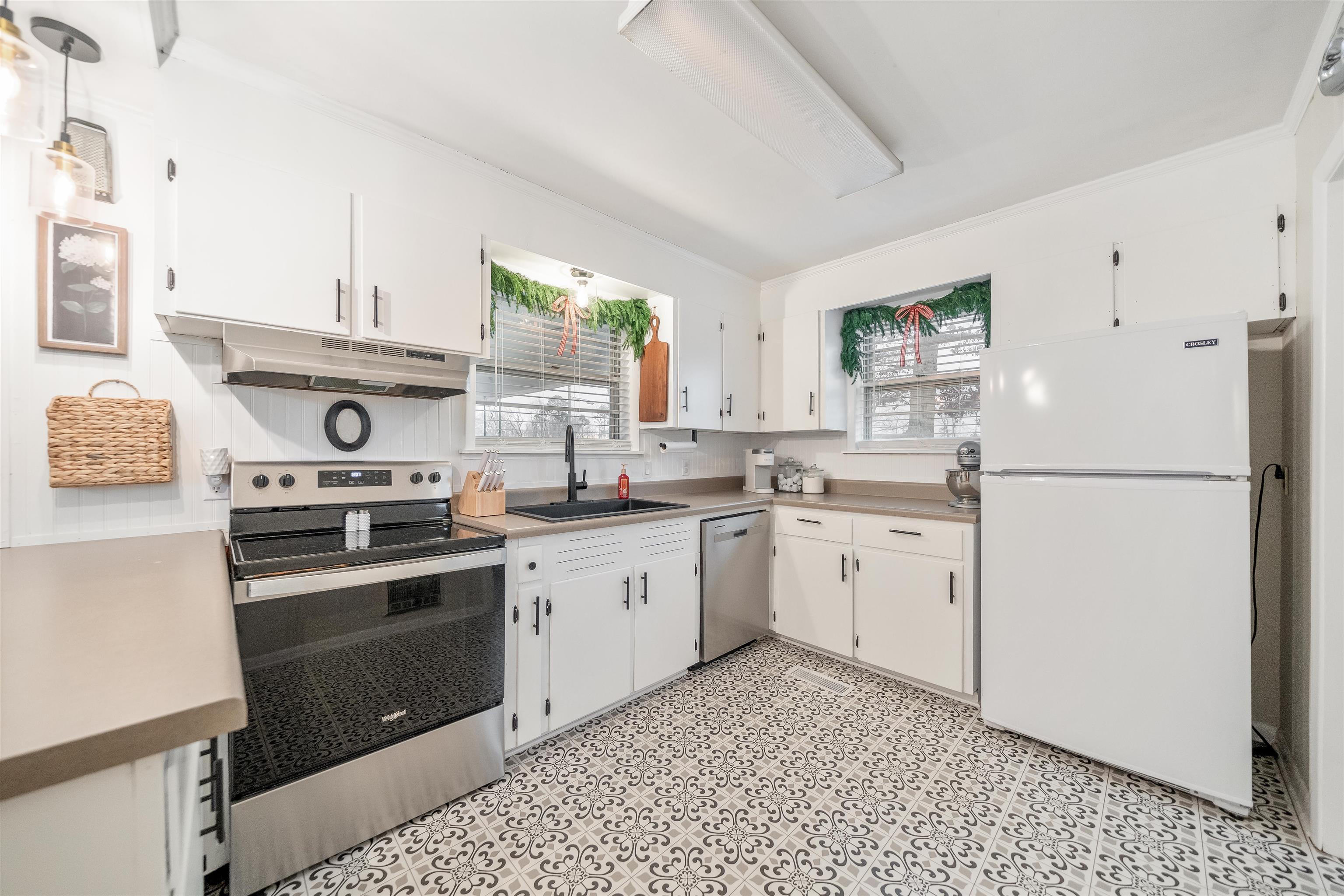 715 Burns Road Ramer, TN 38367 - Photo 15 of 20 Kitchen with stainless steel appliances, under cabinet range hood, white cabinets, light countertops, and light floors