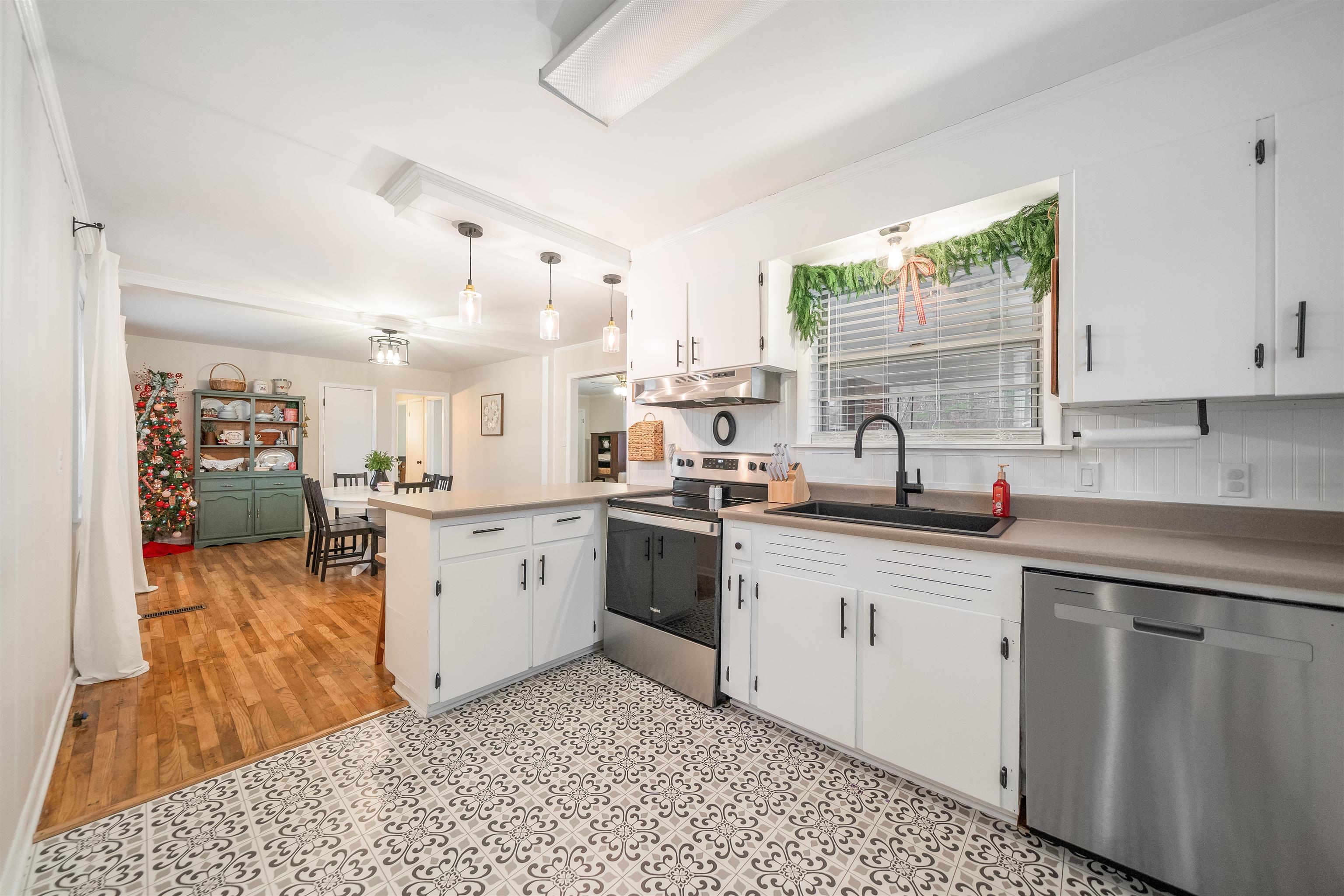 715 Burns Road Ramer, TN 38367 - Photo 16 of 20 Kitchen with a peninsula, stainless steel appliances, white cabinets, light countertops, and hanging light fixtures