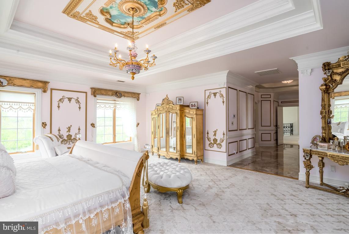 6779 Keller Lime Plant Road Frederick, MD 21703 - Photo 41 of 74 a spacious bedroom with a bed a chandelier and dresser