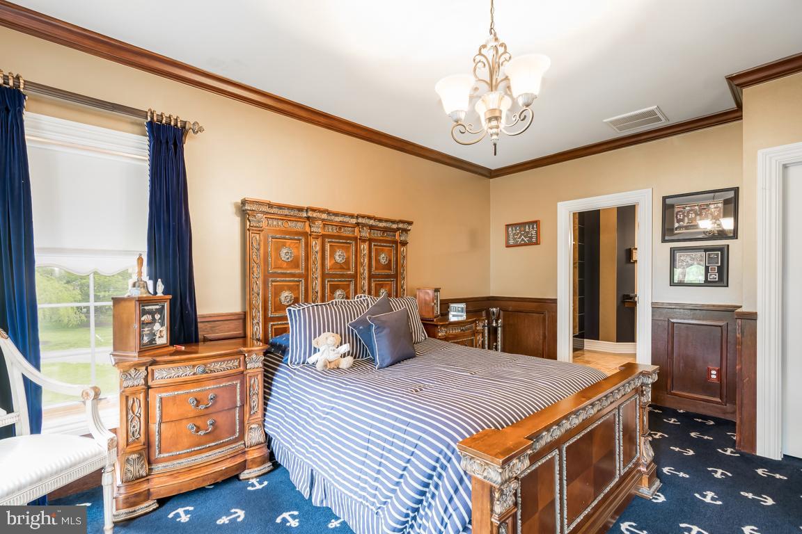 6779 Keller Lime Plant Road Frederick, MD 21703 - Photo 56 of 74 a bedroom with a large bed and a chandelier