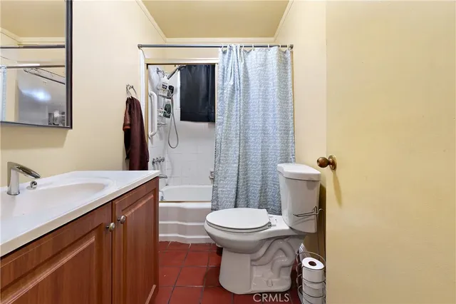 a bedroom with a bed and a refrigerator