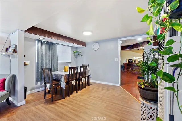 a dining room with furniture potted plants and wooden floor