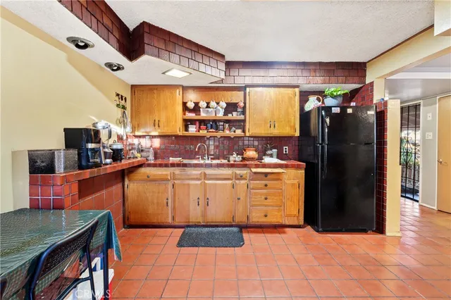 a kitchen with stainless steel appliances granite countertop a refrigerator and a stove