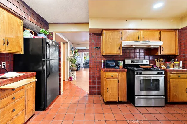 a kitchen with stainless steel appliances granite countertop a refrigerator and a stove