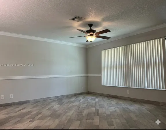en empty room with windows and ceiling fan