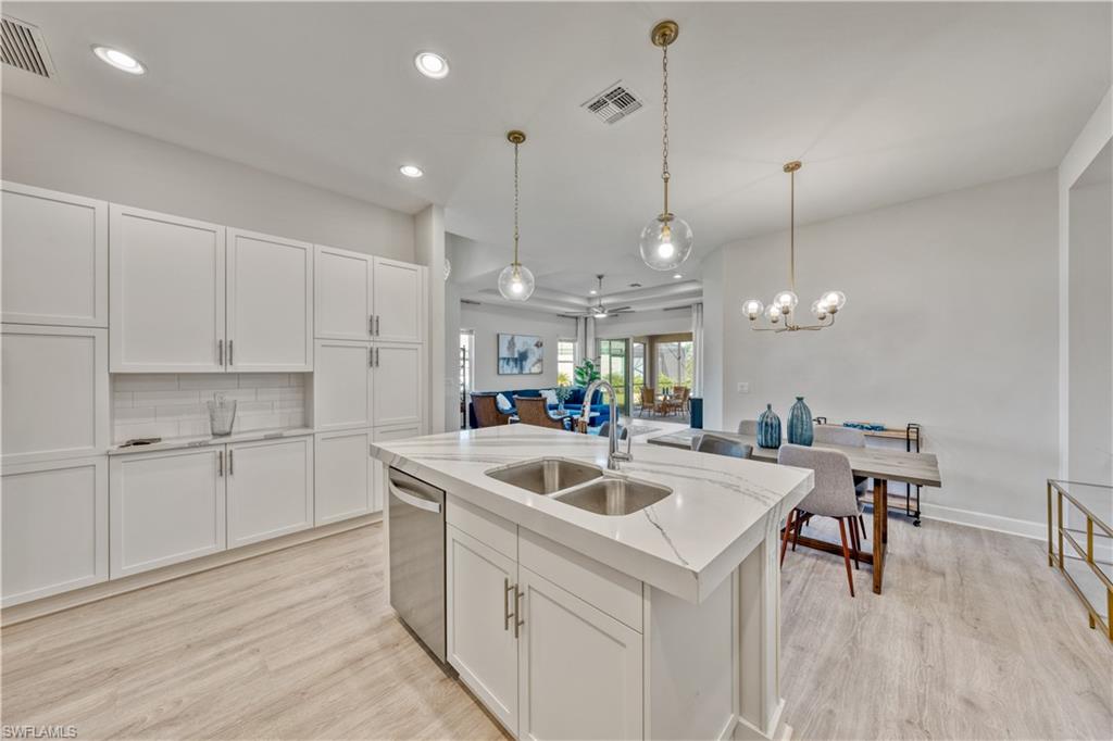 6421 Carnival Road Naples, FL 34113 - Photo 11 of 28 a kitchen with a sink a counter top space appliances and cabinets