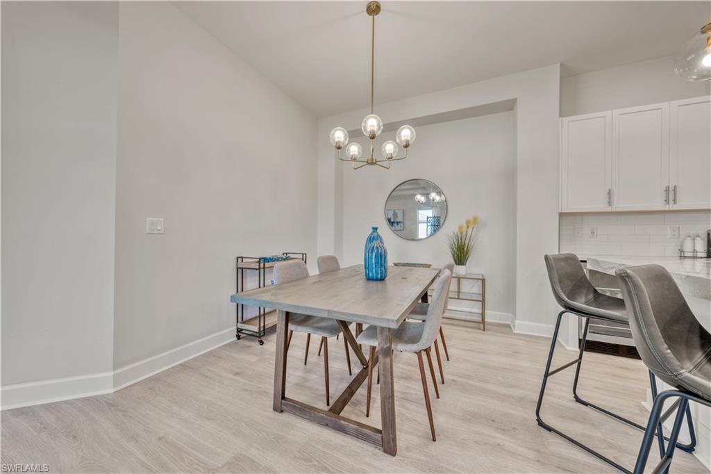 6421 Carnival Road Naples, FL 34113 - Photo 14 of 28 a view of a dining room with furniture and wooden floor
