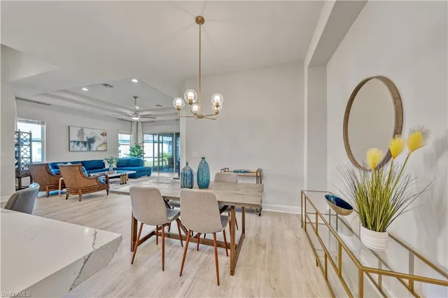 a view of a dining room with furniture a chandelier and wooden floor