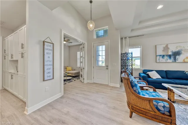 a living room with furniture a wooden floor and a chandelier