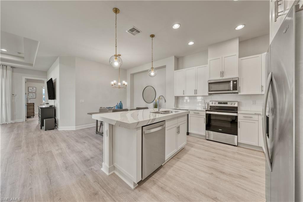 6421 Carnival Road Naples, FL 34113 - Photo 8 of 28 a kitchen with a sink stainless steel appliances and cabinets