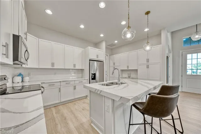 a kitchen with a dining table cabinets appliances and a counter top space