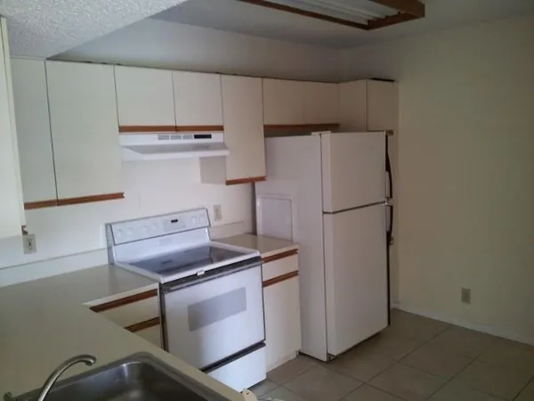 a kitchen with cabinets and a refrigerator