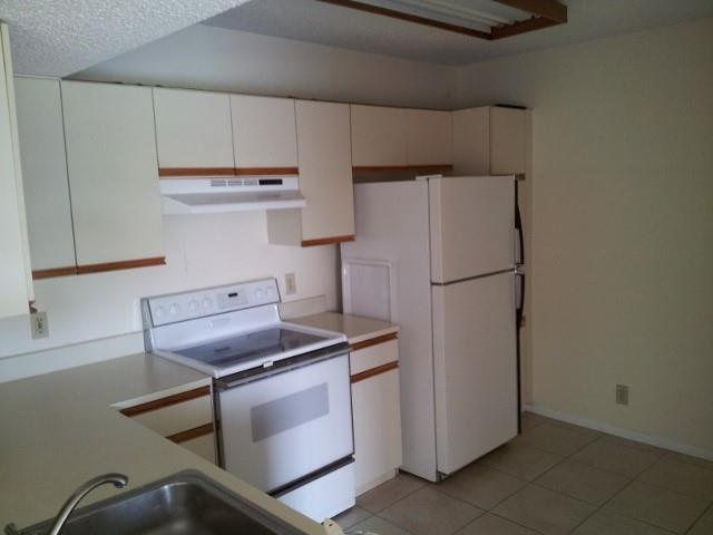 8761 Wiles Road, Unit 303 Coral Springs, FL 33067 - Photo 2 of 5 a kitchen with cabinets and a refrigerator