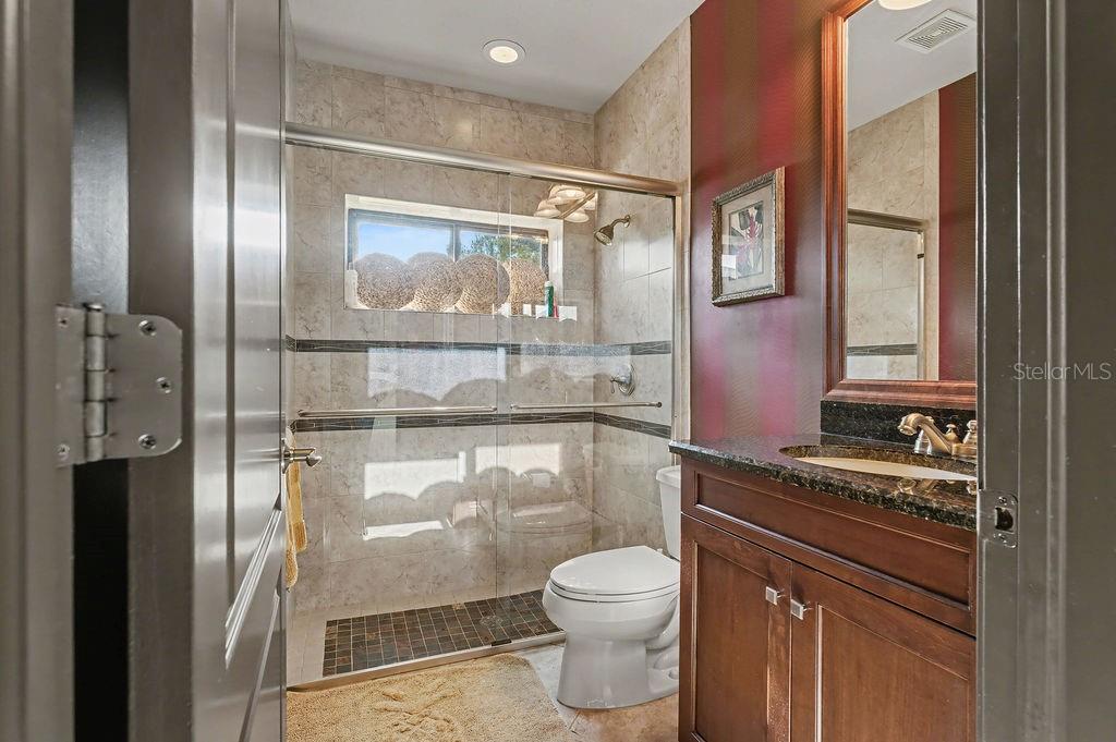 6662 Southwest 179th Ave Road Dunnellon, FL 34432 - Photo 30 of 51 a bathroom with a granite countertop sink mirror toilet and shower