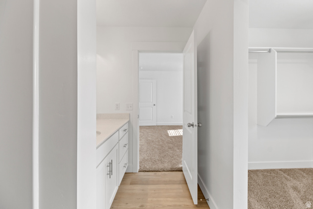 1271 West 500 South Logan, UT 84321 - Photo 17 of 26 Vanity area featuring a quartz countertop, white cabinetry with brushed nickel hardware, and wood-finish flooring