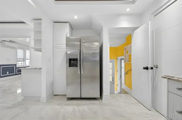 a room with lots of white furniture and a chandelier