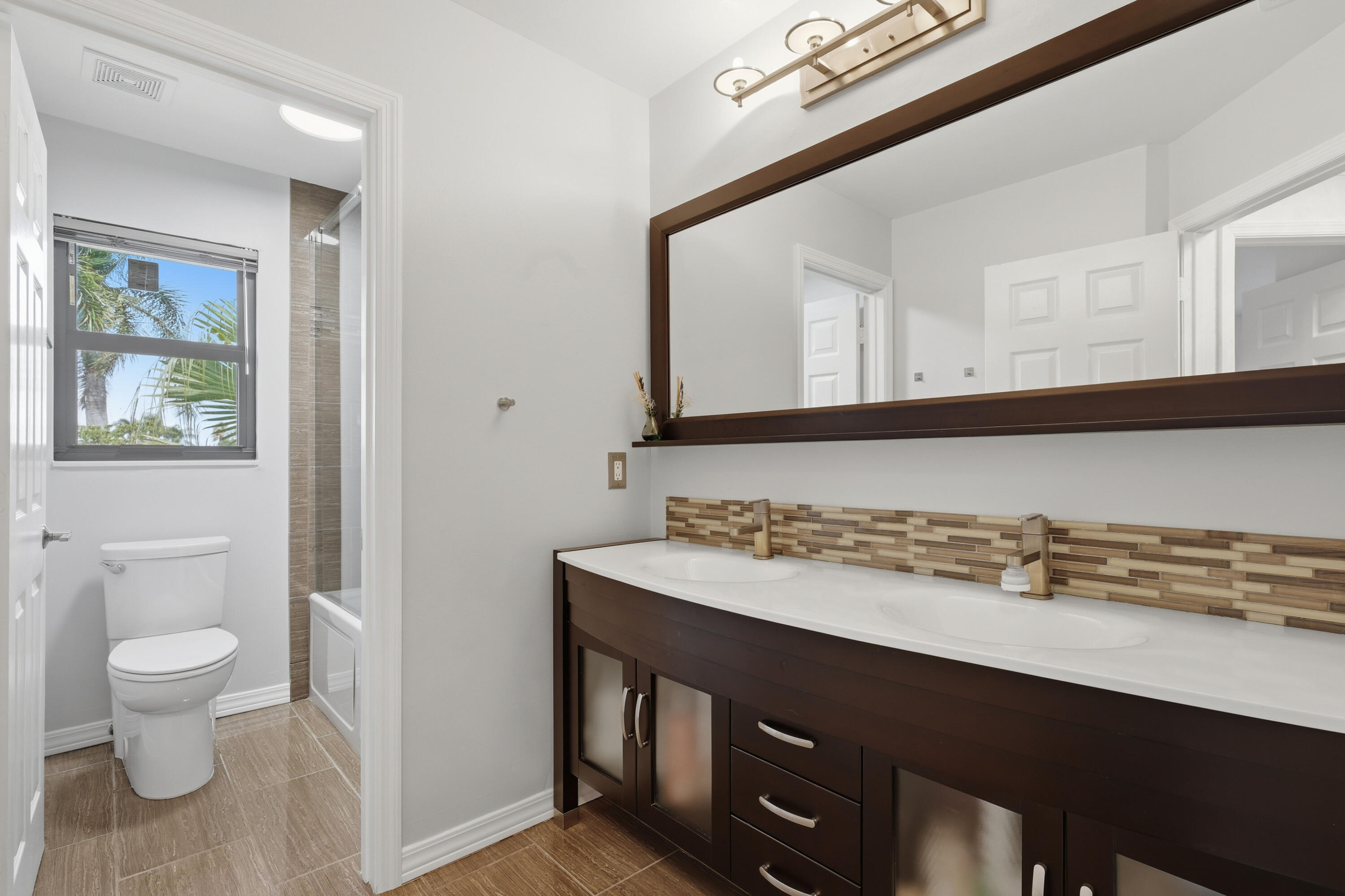22257 Vista Lago Drive Boca Raton, FL 33428 - Photo 38 of 82 a bathroom with a sink a toilet and a mirror