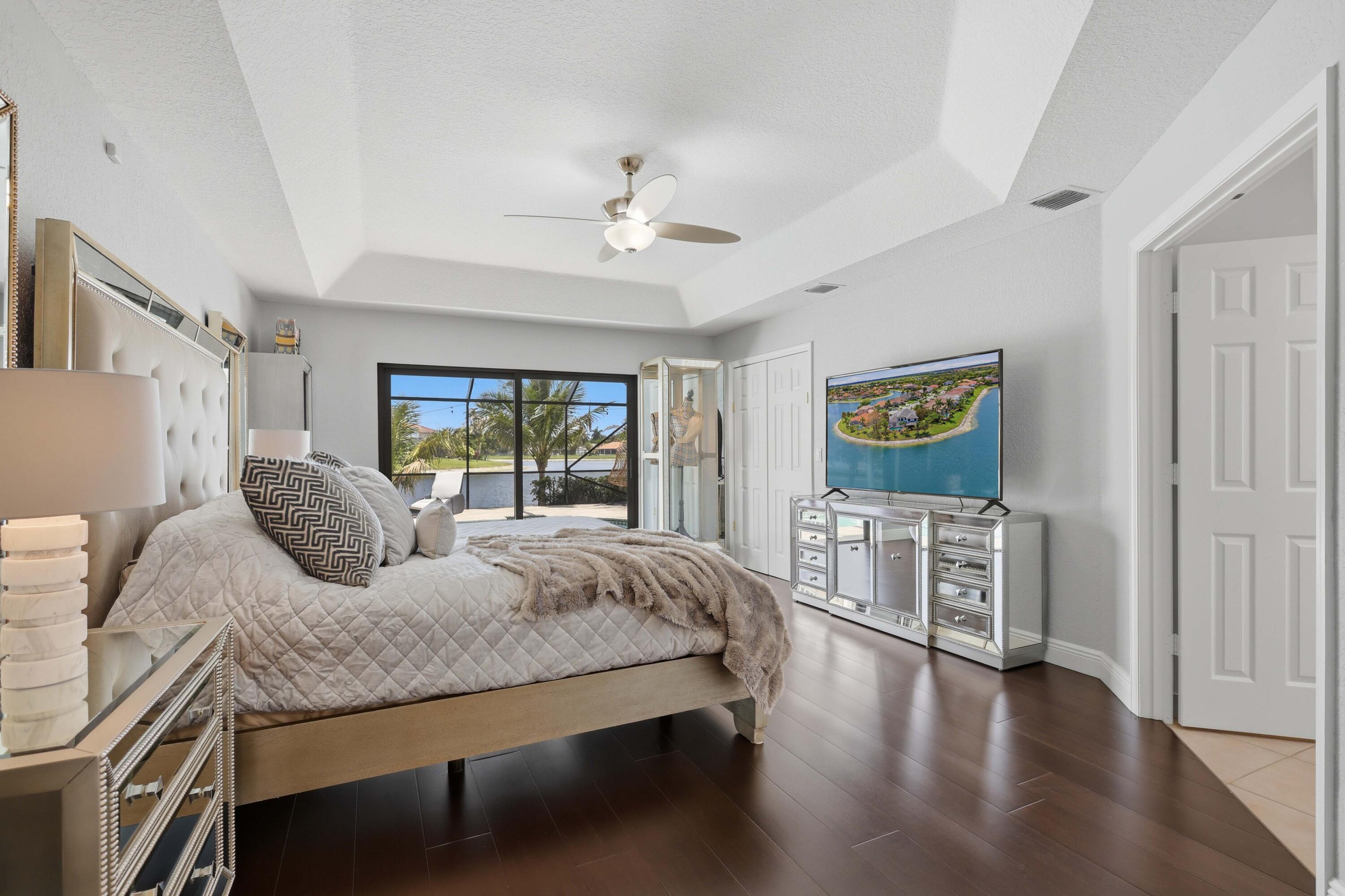 22257 Vista Lago Drive Boca Raton, FL 33428 - Photo 46 of 82 a bedroom with a large bed and a chandelier